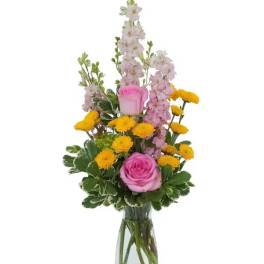 Pink roses and yellow pompon flowers in a clear glass vase