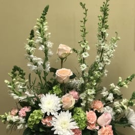 Pastel floral arrangement with roses, white daisies, and tall white spikes