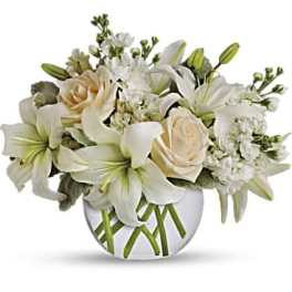 White lilies and cream roses in a round glass vase