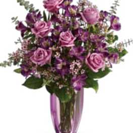 Purple and pink bouquet in a tall glass vase