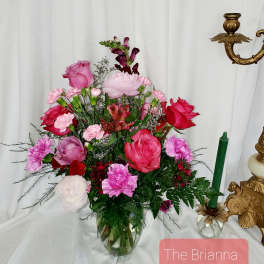 Pink and red mixed flower arrangement in a glass vase