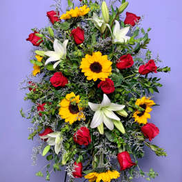 Standing spray with red roses, white lilies, and yellow sunflowers
