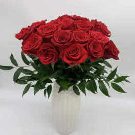 Red roses arranged in a white vase