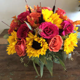 Bouquet of bright roses and sunflowers in a low arrangement