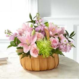 Pink lilies and roses in a pumpkin-shaped container