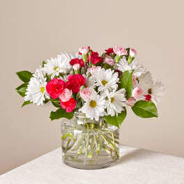 Bouquet of white daisies and pink carnations in a clear glass vase