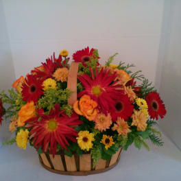 Basket of red, orange, and yellow flowers with a handle