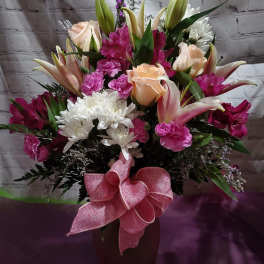 Bouquet of pink and white flowers in a vase with a pink bow