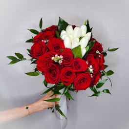 Bouquet of red roses and white tulips with greenery