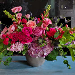 Mixed pink floral arrangement in a gray vase