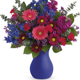 Colorful bouquet in a blue vase with pink, purple, and blue flowers