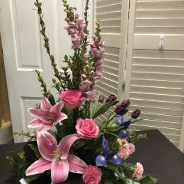 Pink lilies, roses, and purple flowers in a low black wrap