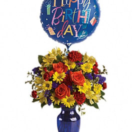 Birthday balloon above a colorful flower arrangement in a blue vase