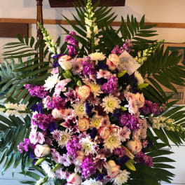 Large standing floral spray with pink, white, and purple flowers