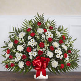 Large red and white floral spray with a red ribbon bow