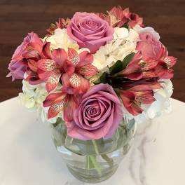Pink roses and white hydrangeas in a clear glass vase