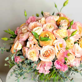 Bouquet of blush and peach roses in a glass vase
