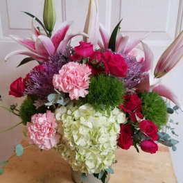 Mixed bouquet with lilies, roses, carnations, and hydrangea in a vase