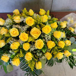 Yellow roses arranged with white filler flowers and greenery