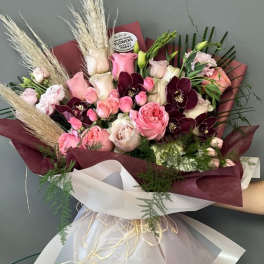Bouquet of pink and burgundy roses with pampas grass and white wrap