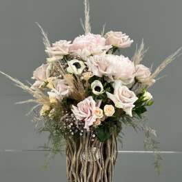 Blush rose arrangement in a tall decorative vase