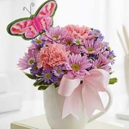 Pink and purple bouquet in a white mug with a butterfly pick