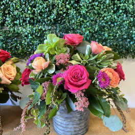 Mixed bouquet of roses and succulents in a metal vase