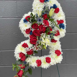 Floral standing spray in the shape of a number 4 with red, white, and blue flowers