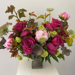 Bouquet of magenta roses and pink peonies in a gray vase