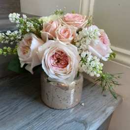 Pink roses arranged in a small ceramic vase