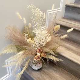 Dried floral arrangement in a small vase on a staircase