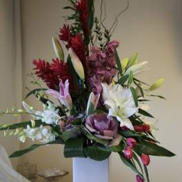 Tall mixed floral arrangement in a white rectangular vase
