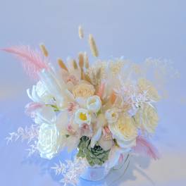 White floral arrangement with pink accents in a small vase