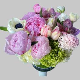 Bouquet of pink peonies, tulips, orchids, and hydrangeas in a vase