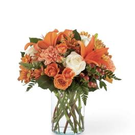 Orange and white mixed bouquet in a clear glass vase