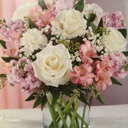 Pink and white bouquet of roses and alstroemeria in a clear glass vase