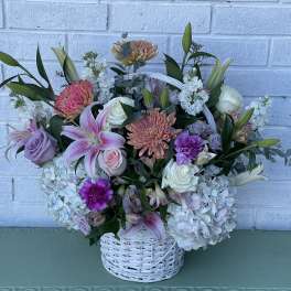 Basket arrangement of pink, lavender, and white flowers