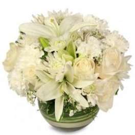 White floral arrangement in a green glass bowl vase
