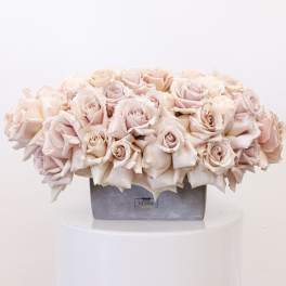 Pale pink rose arrangement in a gray rectangular vase