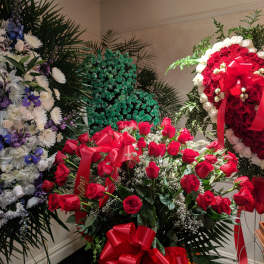 Large red rose arrangement with ribbon bows in a room
