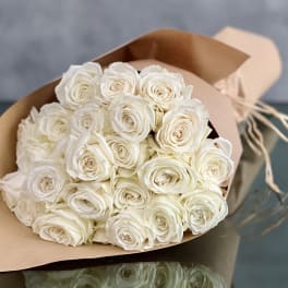Bouquet of white roses wrapped in tan paper