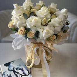 Bouquet of white roses and cream spray roses in a ribbon-tied box