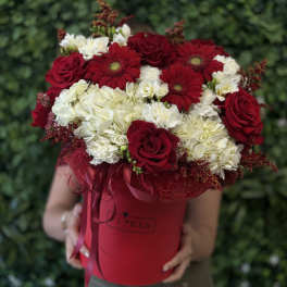 Red roses and white hydrangeas in a red hatbox