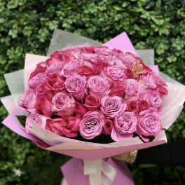 Bouquet of pink roses wrapped in pastel paper with a ribbon