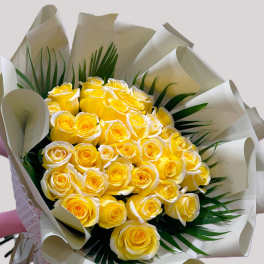 Bouquet of yellow roses wrapped in white paper