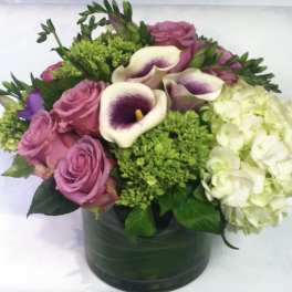 Pink roses and white calla lilies in a green vase