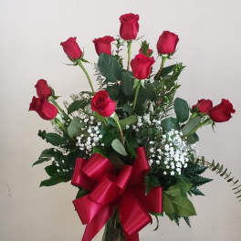 Red roses in a glass vase with a large red ribbon