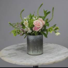 Pink roses and white flowers in a ribbed metal vase