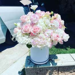 Large pastel pink and white flower arrangement in a white hatbox-style container