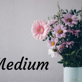 Bouquet of pink and lavender daisies in a light blue vase